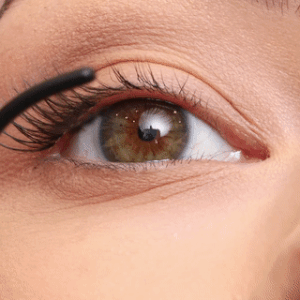 Gros plan d'un mannequin appliquant les cils en grappe